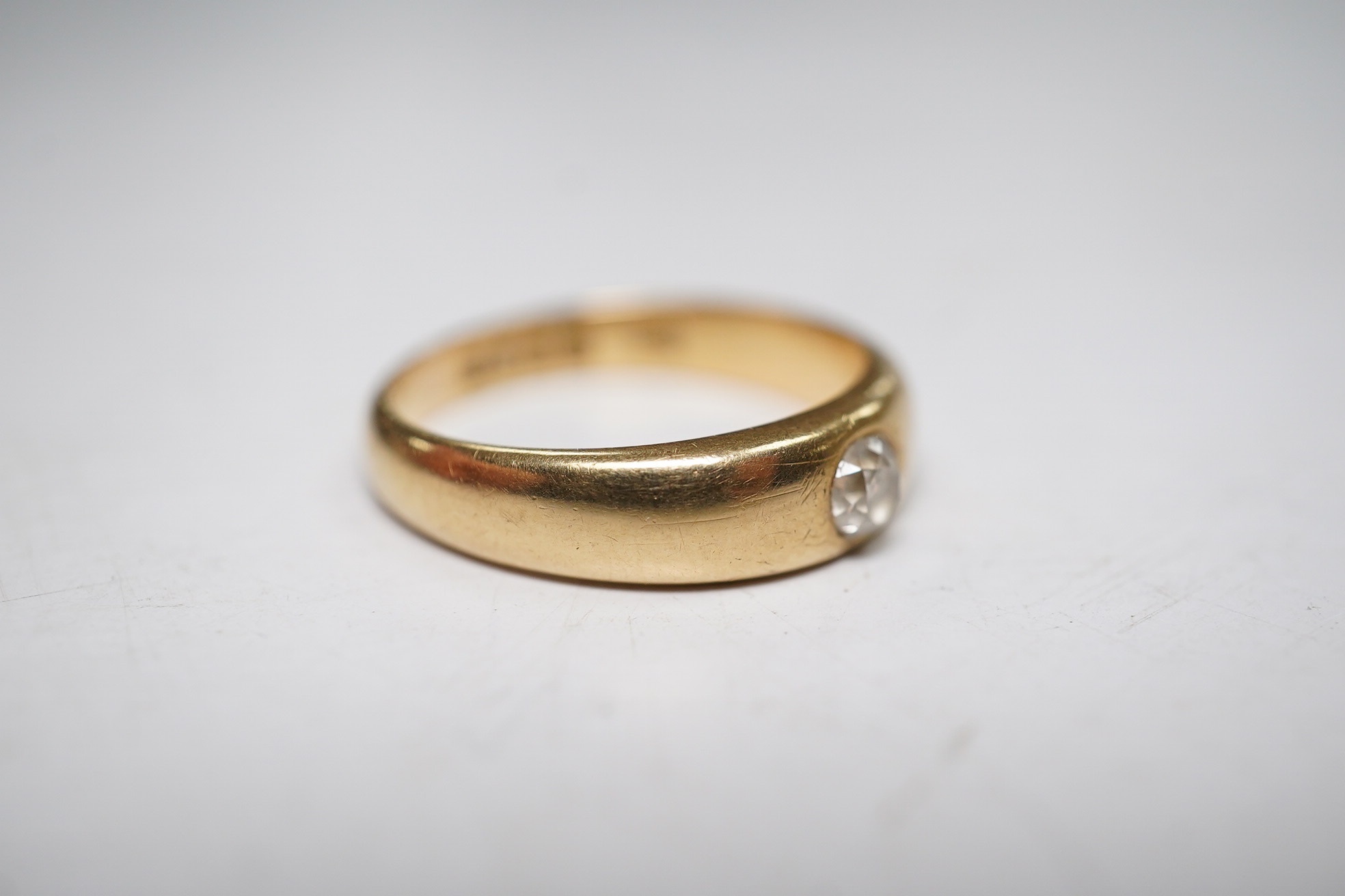 A late Victorian 18ct gold and single stone gypsy set diamond ring, size P, gross weight 5.3 grams. Condition - fair